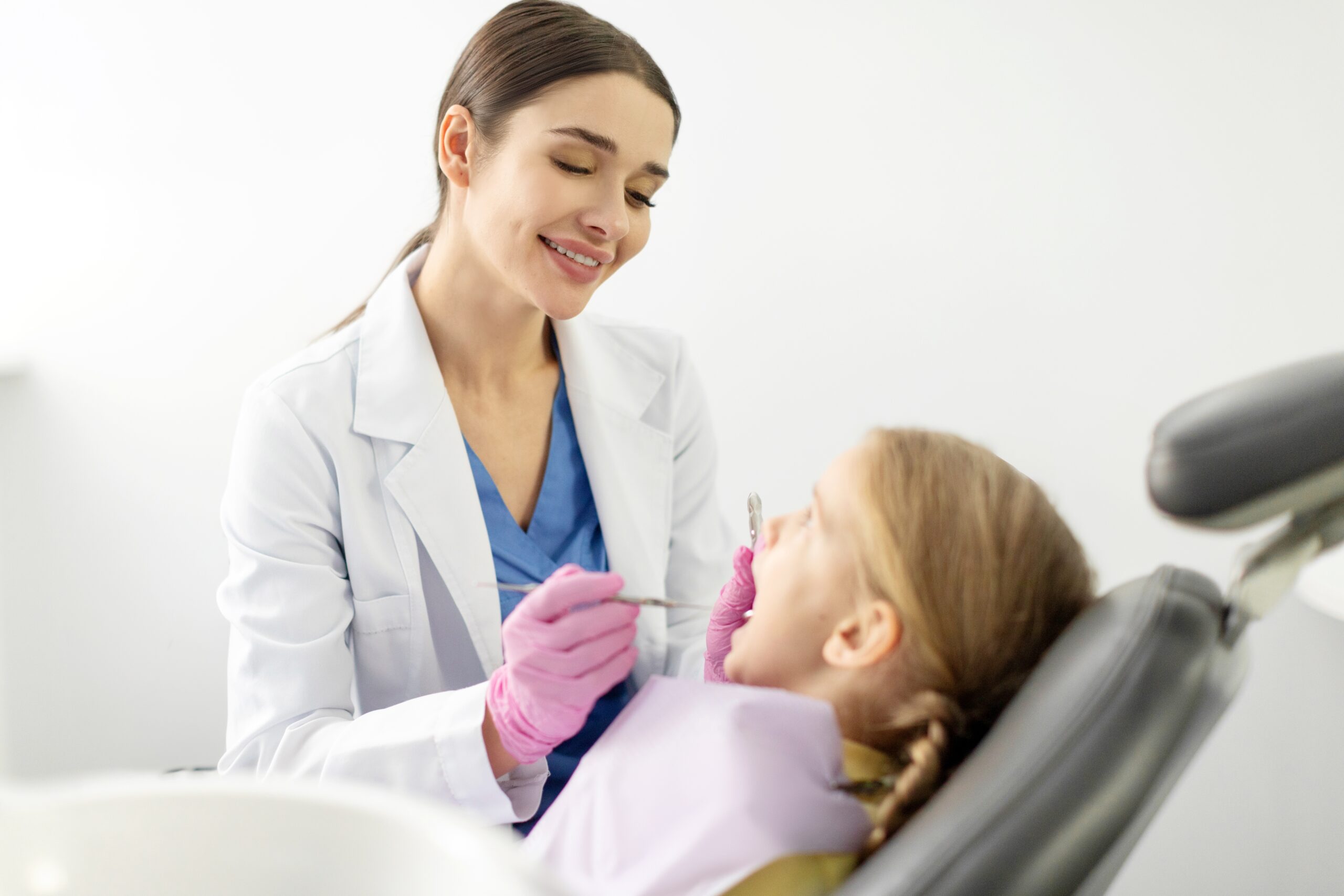 Top Dentist Austin treating a young girl’s tooth as she sits in the dental chair